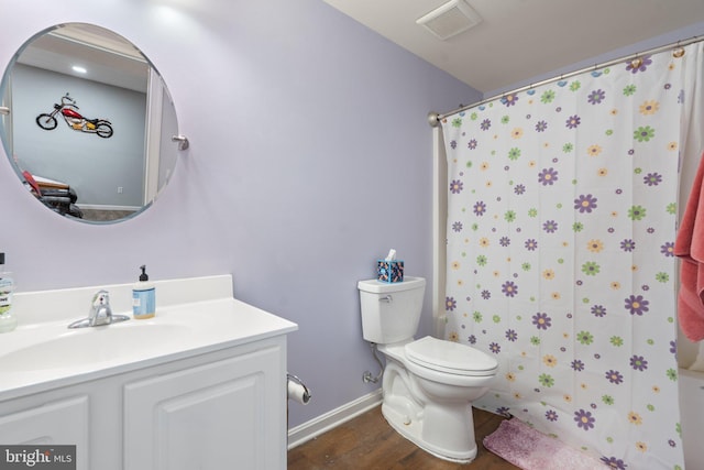 bathroom with hardwood / wood-style flooring, vanity, curtained shower, and toilet