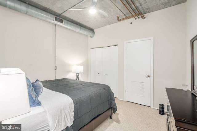 carpeted bedroom with ceiling fan and a closet