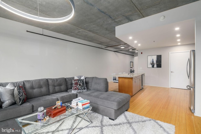 living room featuring sink and light hardwood / wood-style floors