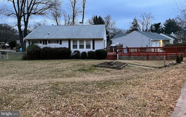 back of property featuring a deck and a lawn