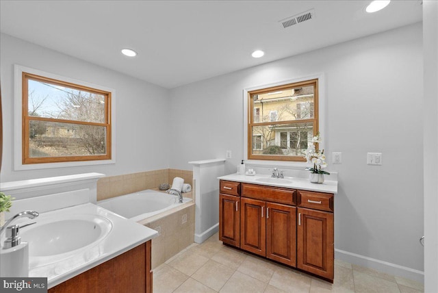 bathroom featuring vanity, tiled bath, and tile patterned floors