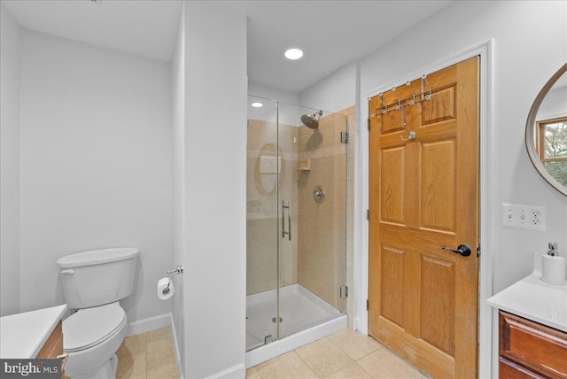 bathroom with vanity, a shower with shower door, tile patterned floors, and toilet