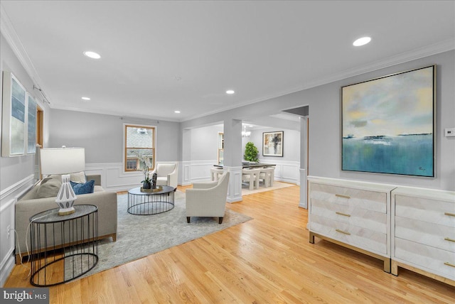 living room with crown molding and light wood-type flooring