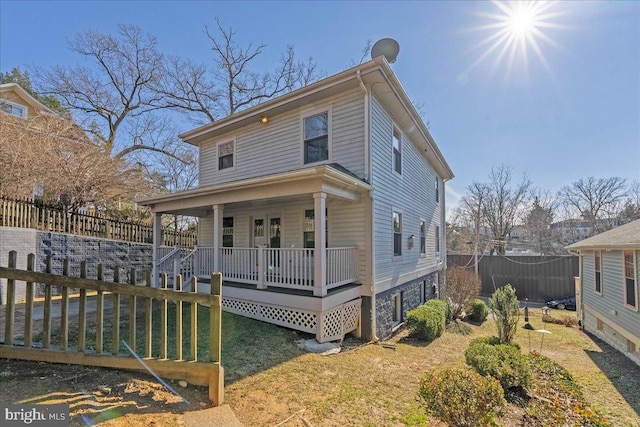 view of front of home featuring covered porch and a front lawn