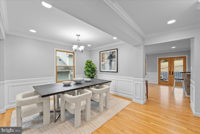 dining room with plenty of natural light, a chandelier, light wood-type flooring, and french doors