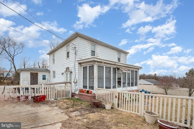 back of property with a sunroom