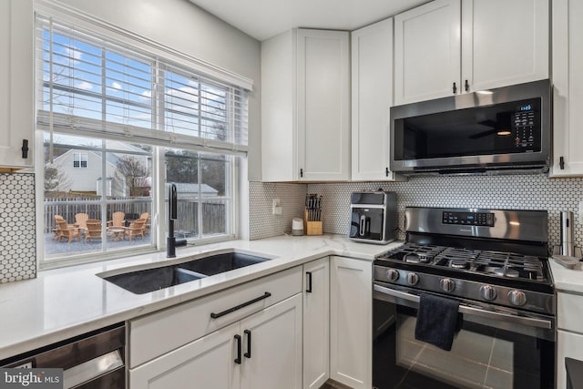 kitchen with range with gas stovetop, stainless steel microwave, decorative backsplash, a sink, and dishwasher