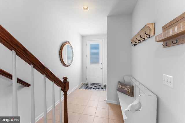 entryway featuring stairs, baseboards, and light tile patterned floors