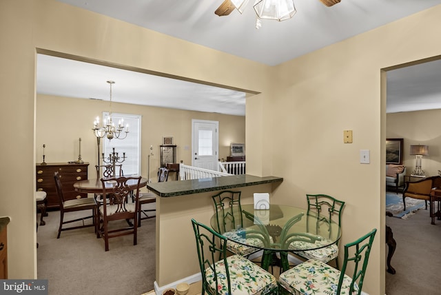 dining space featuring light carpet and ceiling fan with notable chandelier