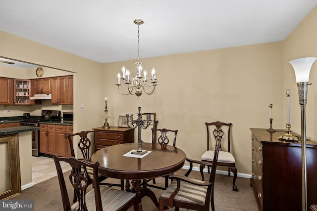 carpeted dining area featuring a chandelier