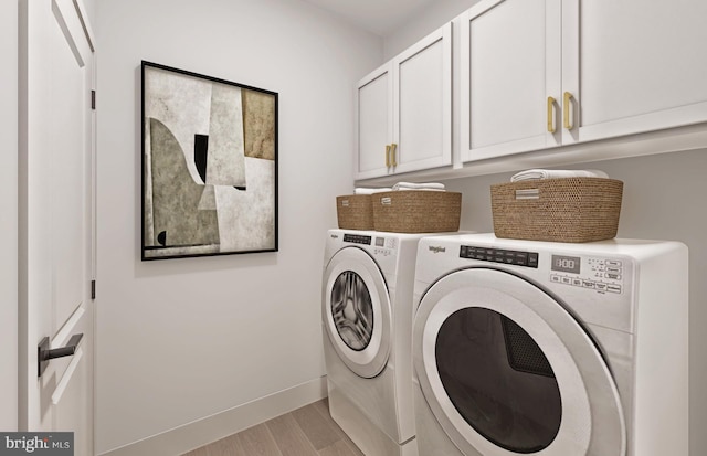 laundry room with cabinets, washer and dryer, and light hardwood / wood-style flooring