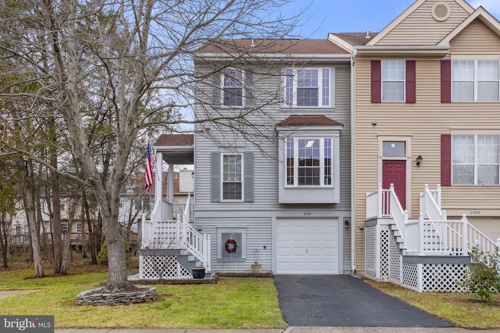 townhome / multi-family property featuring a garage and a front lawn