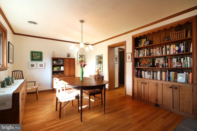 dining space featuring ornamental molding and light hardwood / wood-style floors