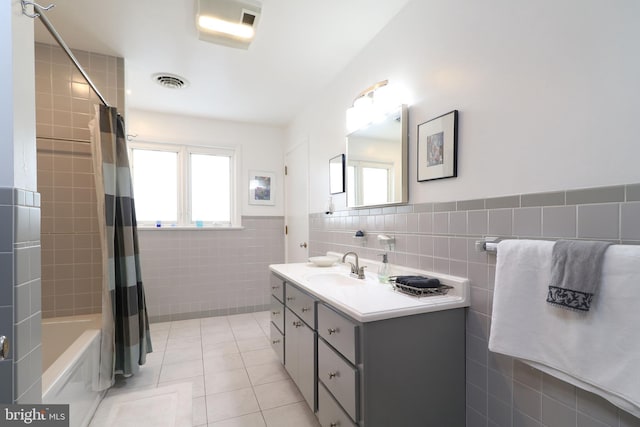 bathroom featuring shower / tub combo with curtain, tile patterned floors, tile walls, and vanity