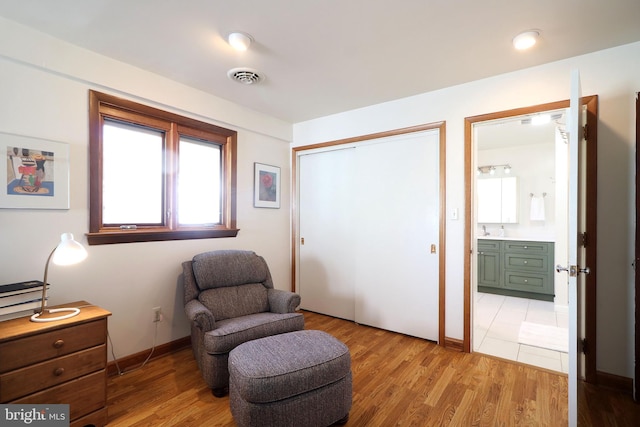 sitting room with sink and light wood-type flooring