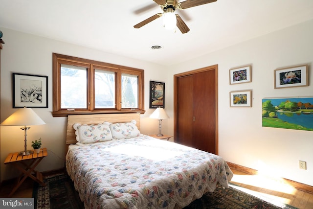 bedroom with wood-type flooring, ceiling fan, and a closet