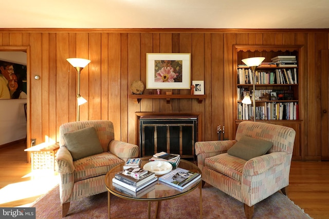 sitting room featuring hardwood / wood-style flooring and wooden walls