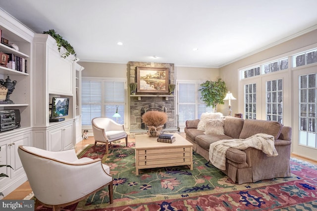 living room featuring built in features, a fireplace, ornamental molding, and dark hardwood / wood-style floors