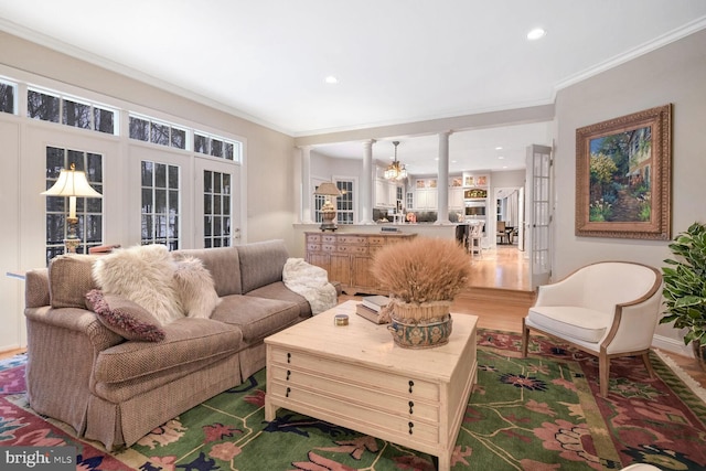 living room with ornate columns, ornamental molding, and wood-type flooring