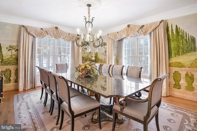 dining room with an inviting chandelier, crown molding, and light hardwood / wood-style floors