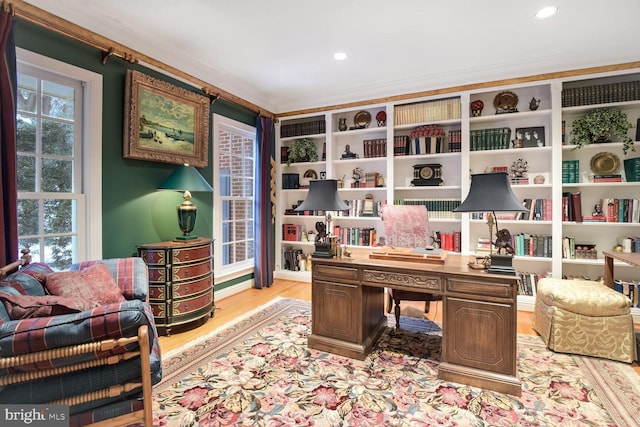 office space with ornamental molding, plenty of natural light, and light wood-type flooring