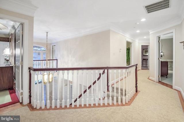 corridor with light carpet, a notable chandelier, and ornamental molding