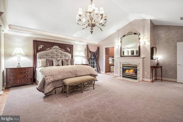 bedroom featuring crown molding, carpet flooring, a fireplace, vaulted ceiling, and a chandelier