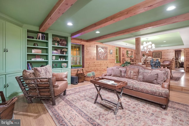 living room featuring beamed ceiling, wooden walls, hardwood / wood-style floors, and an inviting chandelier