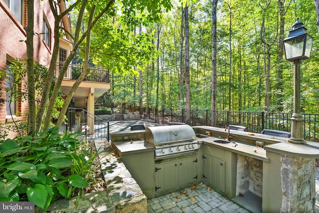 view of patio / terrace with an outdoor kitchen, a grill, and sink