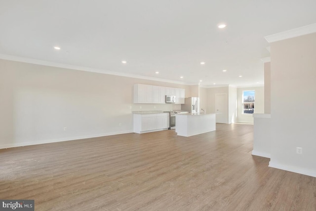 unfurnished living room featuring crown molding and light wood-type flooring