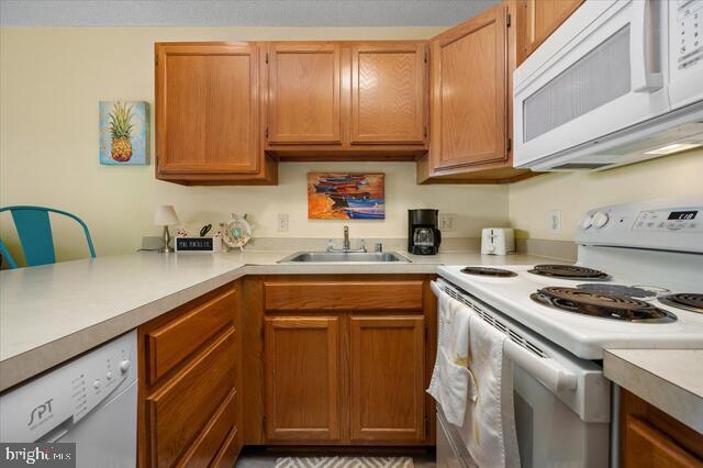 kitchen featuring white appliances and sink