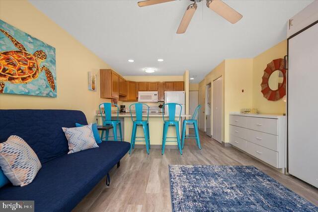 living room featuring ceiling fan and light hardwood / wood-style floors