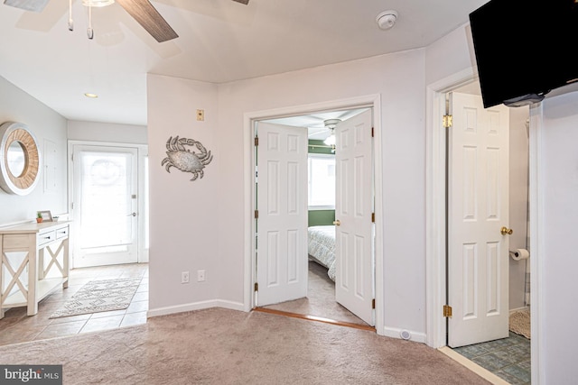 entrance foyer featuring ceiling fan and light colored carpet