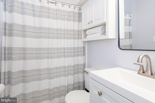 bathroom featuring vanity, curtained shower, and toilet