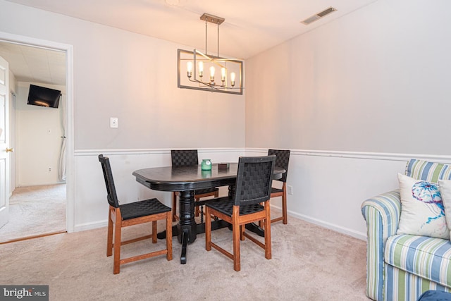 dining space featuring a notable chandelier and light colored carpet