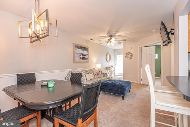 dining room with ceiling fan with notable chandelier and carpet floors