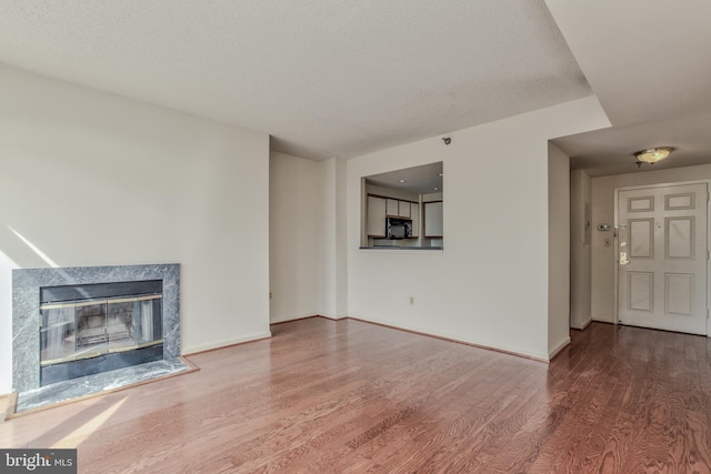 unfurnished living room with a fireplace and wood-type flooring