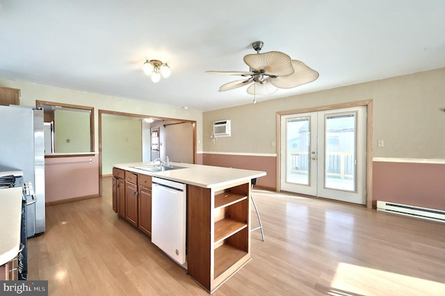 kitchen featuring french doors, sink, light wood-type flooring, white dishwasher, and an island with sink