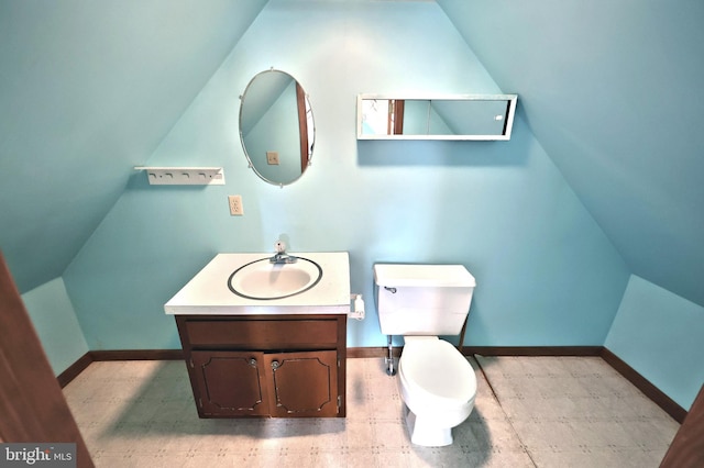 bathroom with vaulted ceiling, vanity, and toilet