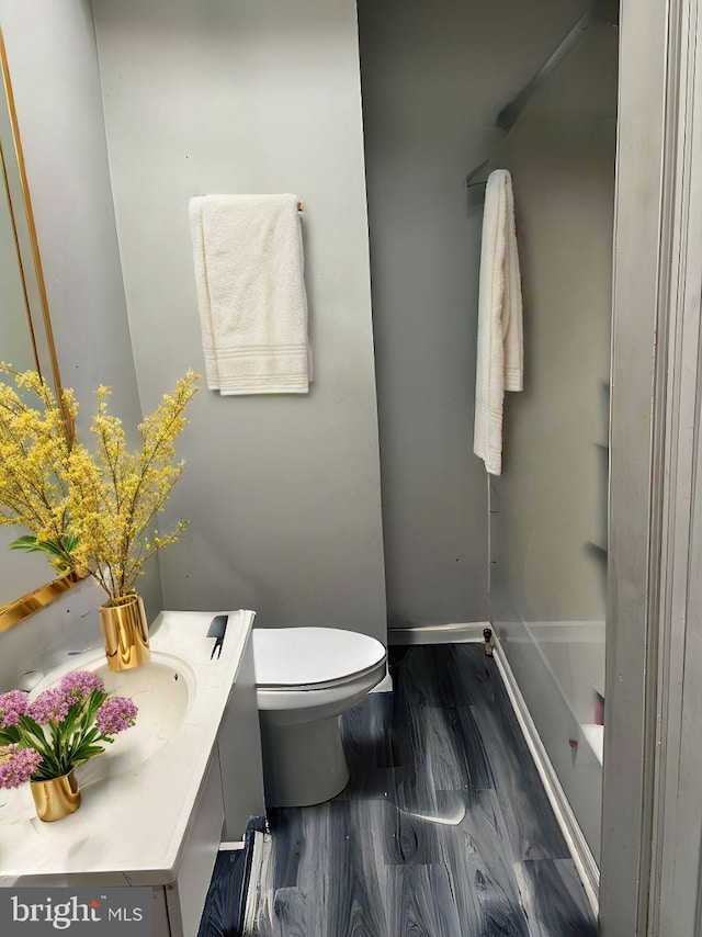 bathroom featuring vanity, hardwood / wood-style flooring, and toilet