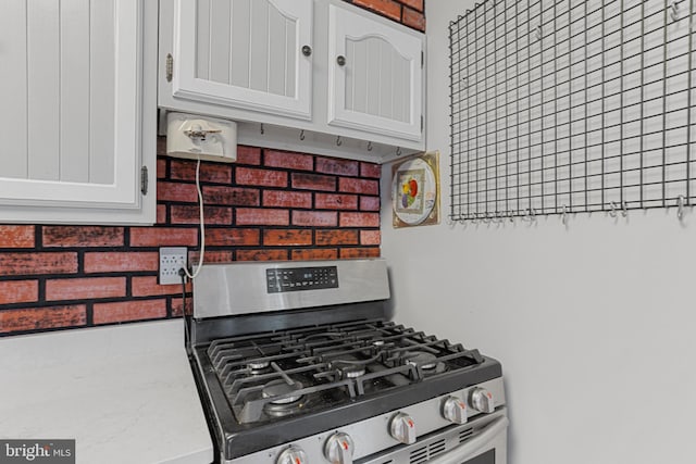 kitchen featuring white cabinetry and stainless steel gas range oven