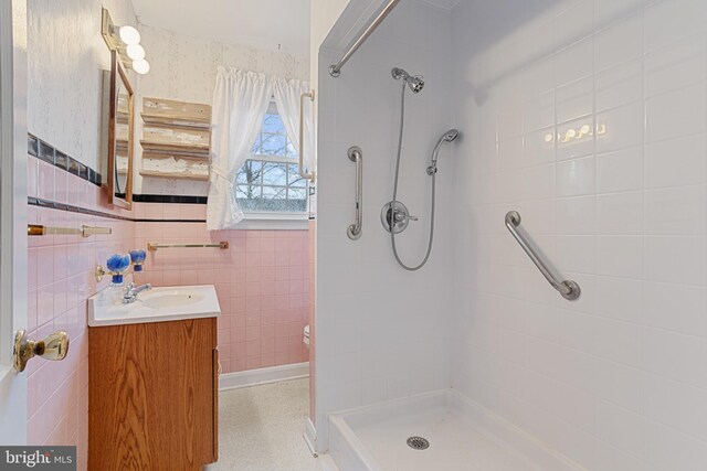 bathroom with vanity, tile walls, and tiled shower