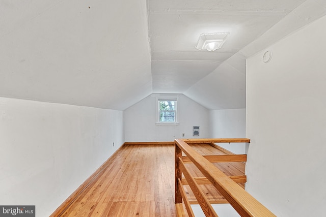 bonus room with wood-type flooring and vaulted ceiling