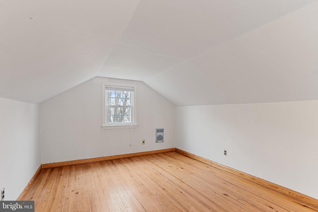 bonus room featuring heating unit, hardwood / wood-style flooring, and vaulted ceiling