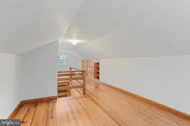 additional living space featuring hardwood / wood-style flooring and lofted ceiling