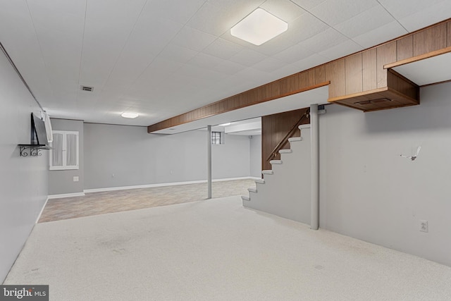 basement featuring wooden walls and carpet