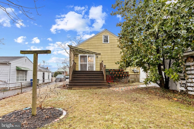 rear view of property featuring a yard