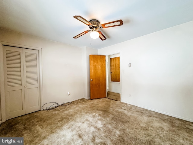 unfurnished bedroom featuring a closet, carpet flooring, a ceiling fan, and baseboards