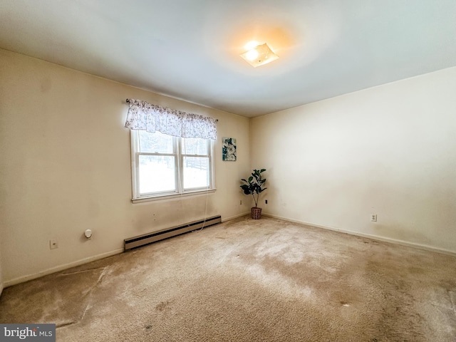 carpeted spare room with a baseboard radiator and baseboards