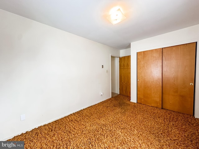 unfurnished bedroom featuring a closet and carpet flooring